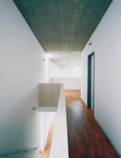 Harmonické uspořádání. Pro řešení interiéru jsou příznačné dřevěné podlahy, bílé stěny a strop z pohledového betonu.
